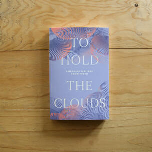 The cover for the anthology To Hold The Clouds. The cover is purple with dark purple and orange wavy lines across the top and bottom. The book is photographed on a wooden desk.